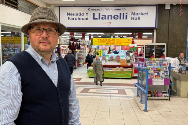 Carl Peters‑Bond standing inside Llanelli Market, speaking about Carmarthenshire Council’s proposals to demolish and relocate the market.